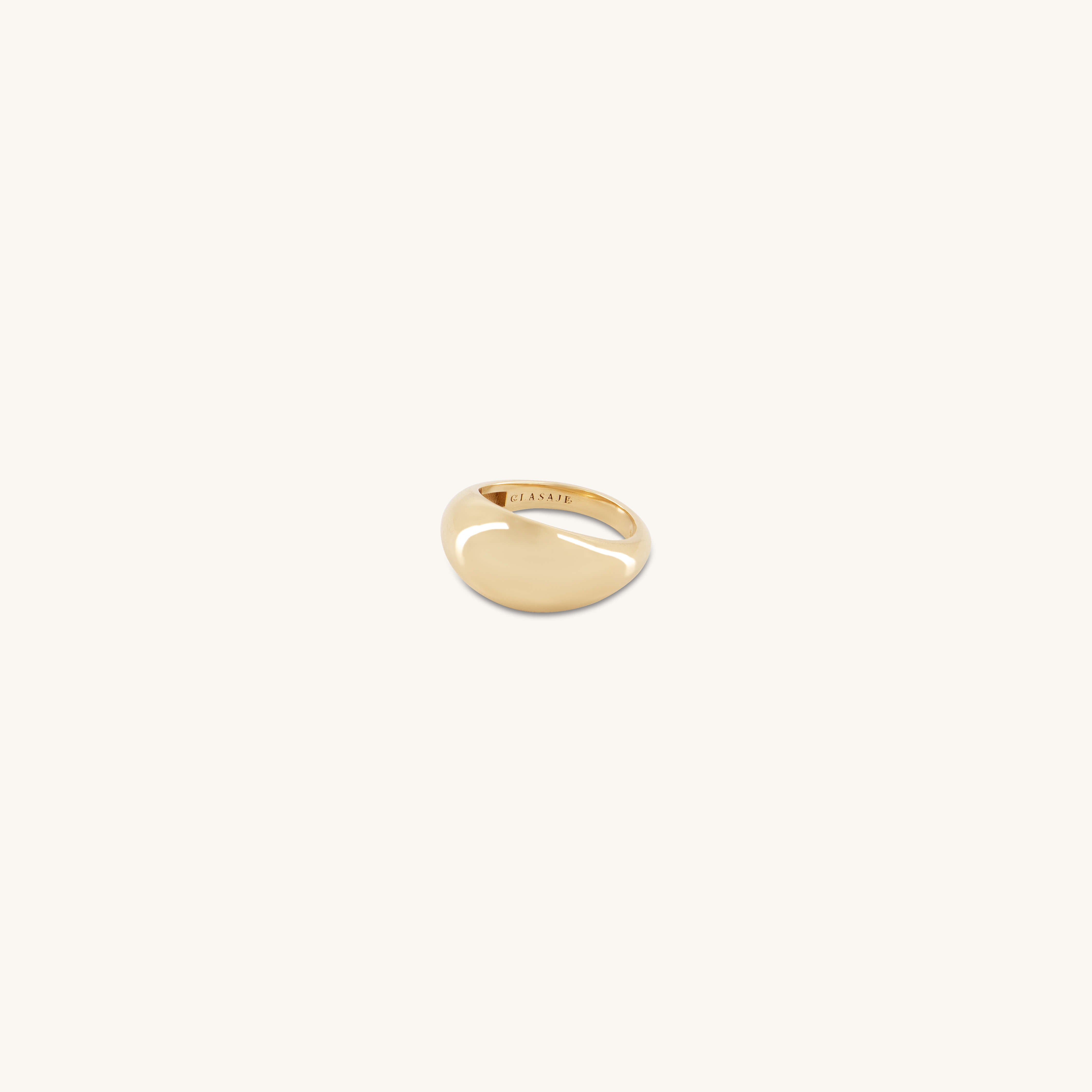 The Glasâje Dôme Ring, crafted in polished solid gold with a smooth, oval top, is displayed centered on a plain off-white background.