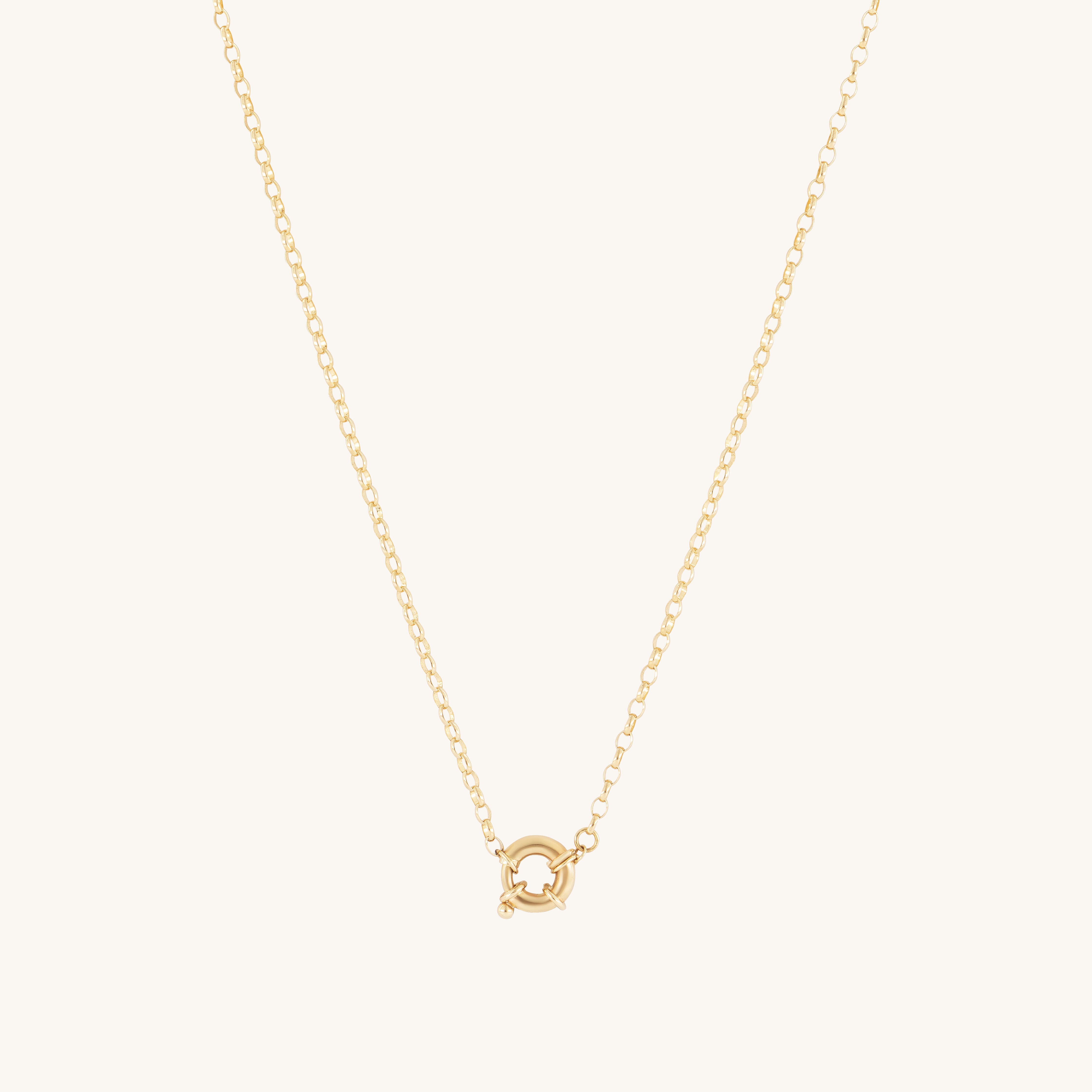 The Glasâje Hosier Necklace features a gold belcher chain with a small circular spring ring clasp pendant at the center, set against an off-white background.