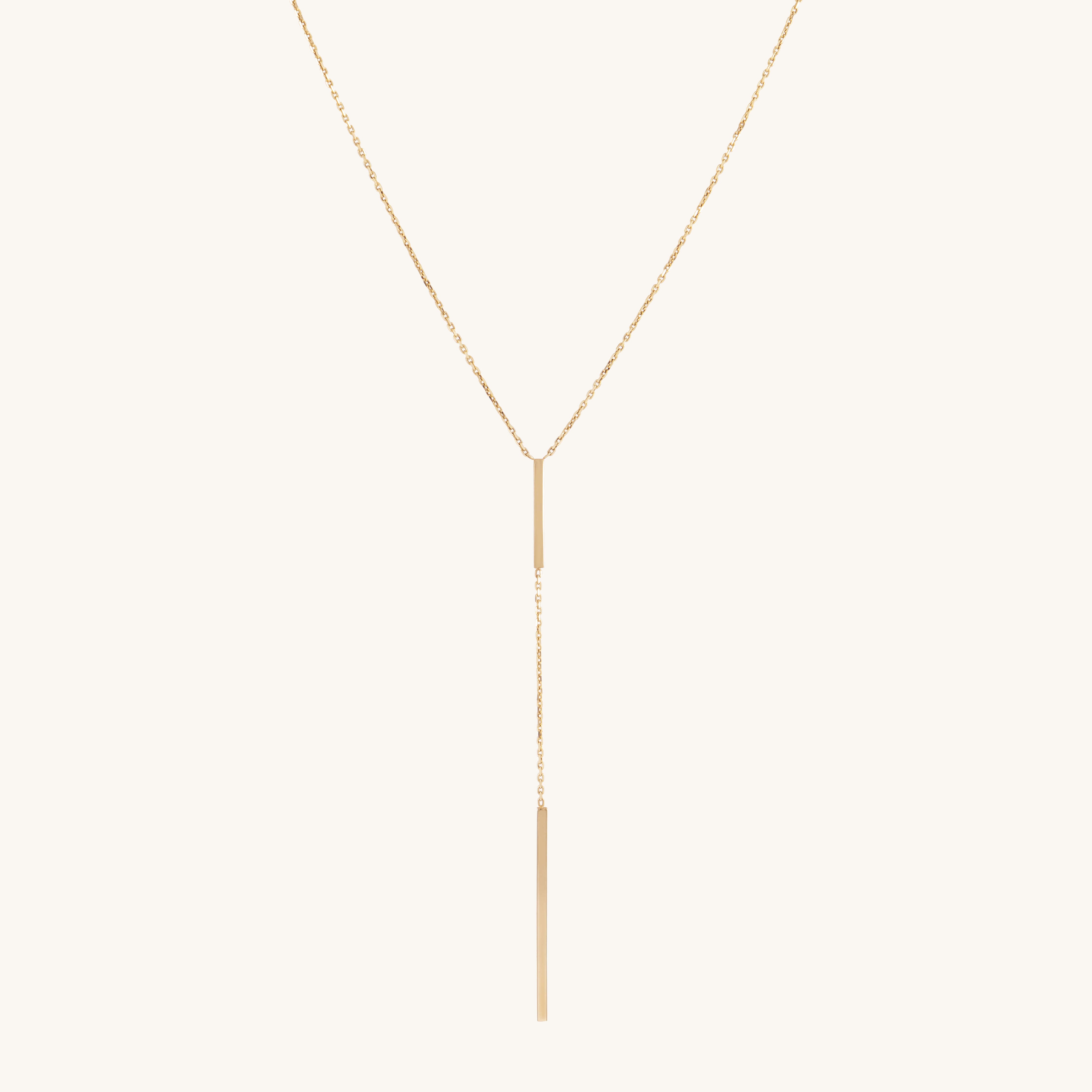 Elegant gold lariat necklace with a thin vertical gold bar pendant, dangling gracefully. The sleek design conveys simplicity and sophistication.