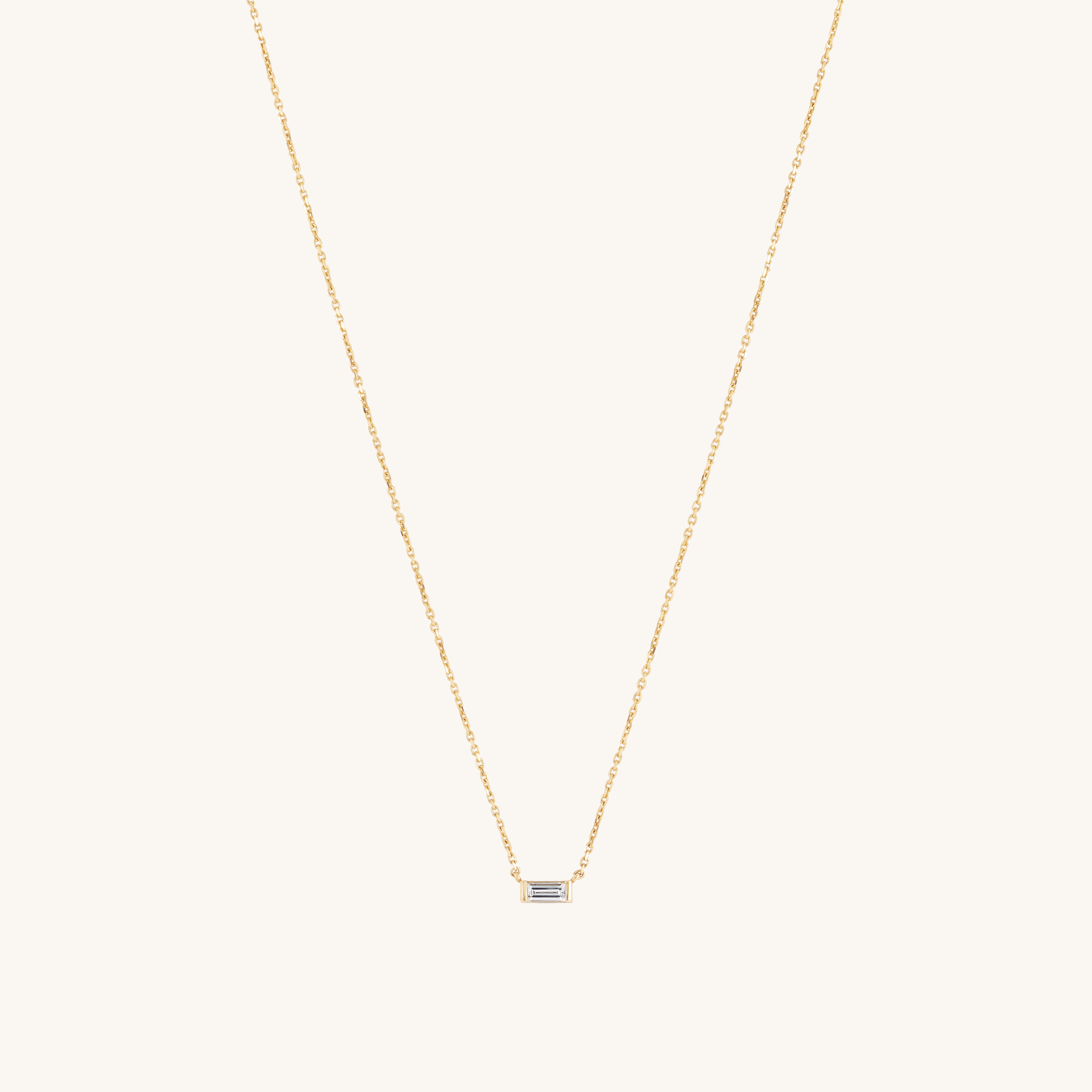 The Siglo Necklace by Glasâje showcases a delicate 9ct solid gold chain and a small rectangular baguette-cut ethically-grown diamond pendant, elegantly set against a plain white background.