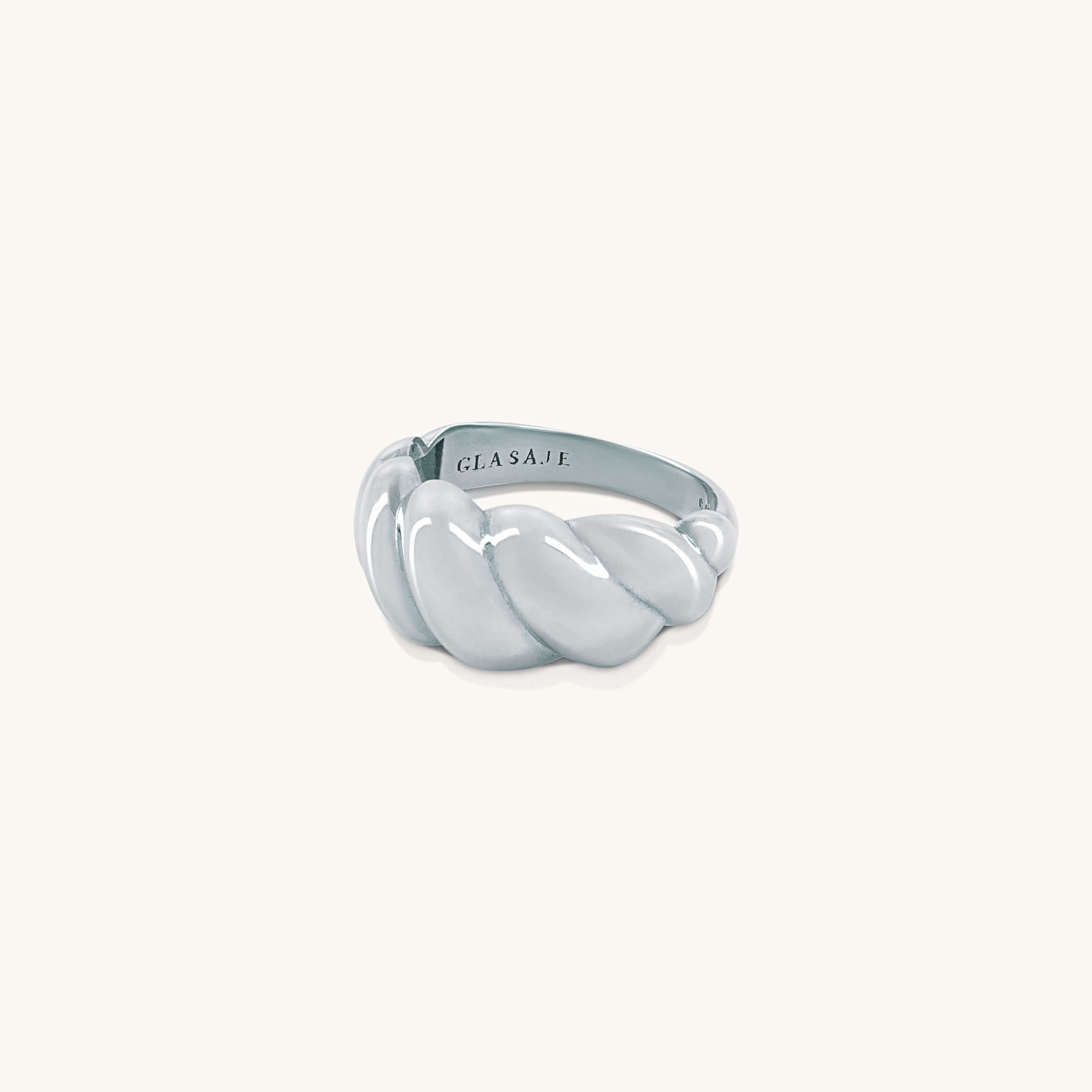Silver ring with a twisted design on a white background