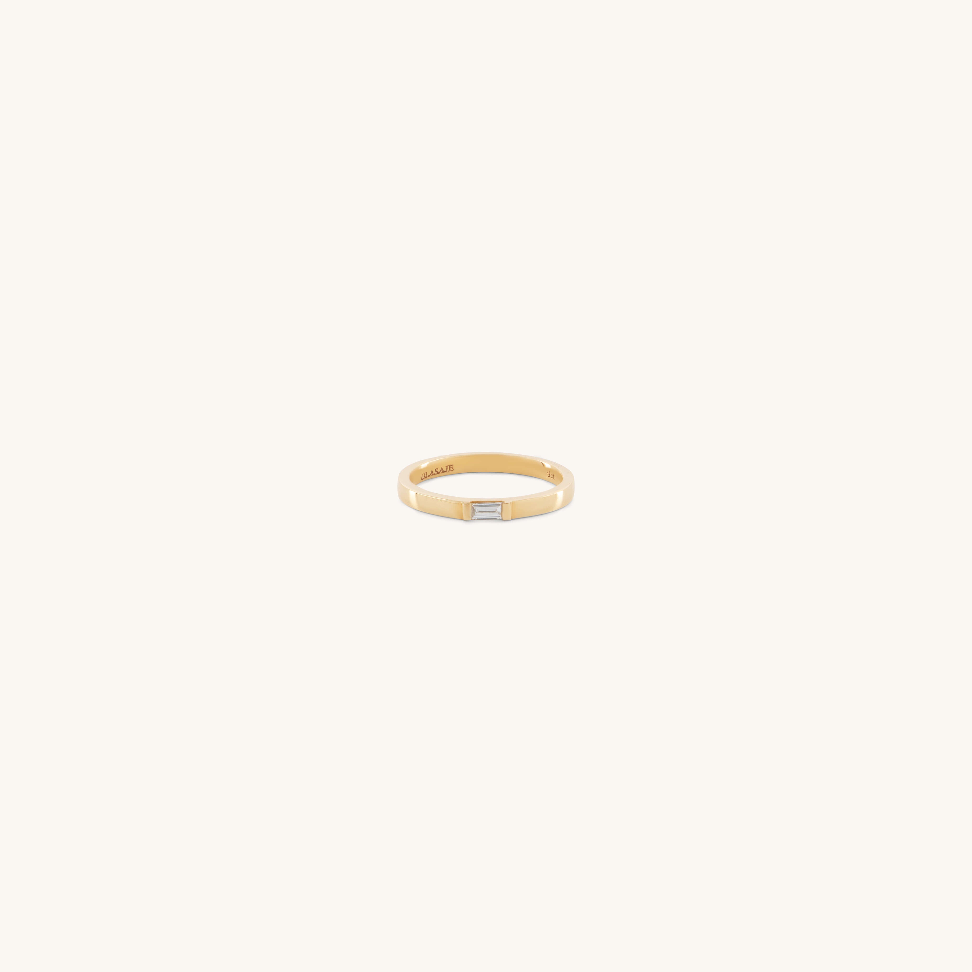 The Glasâje Siglo Ring features a simple gold band with a small rectangular ethical diamond set at the center, shown against an off-white background.
